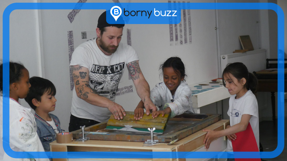 L'artiste sérigraphe Val l'Enclume fabrique un fanzine avec des enfants de Borny. © Photo Kossi Simplice Honyiglo, graphisme Aurélien Zann / Bornybuzz